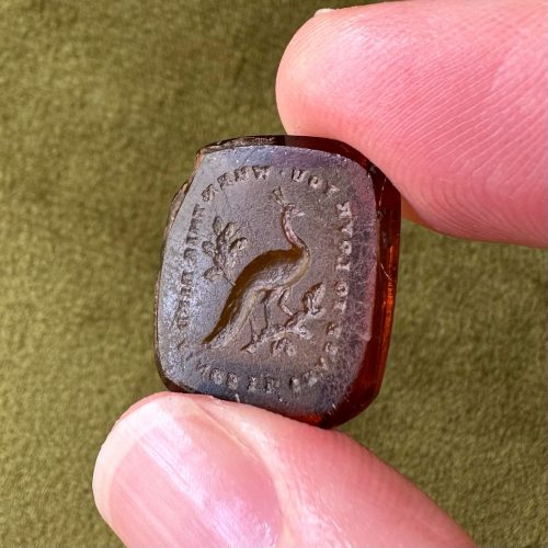 Rare golden brown paste intaglio with image of a peacock - text reads ‘I’ll cease to love you when this bird sings’