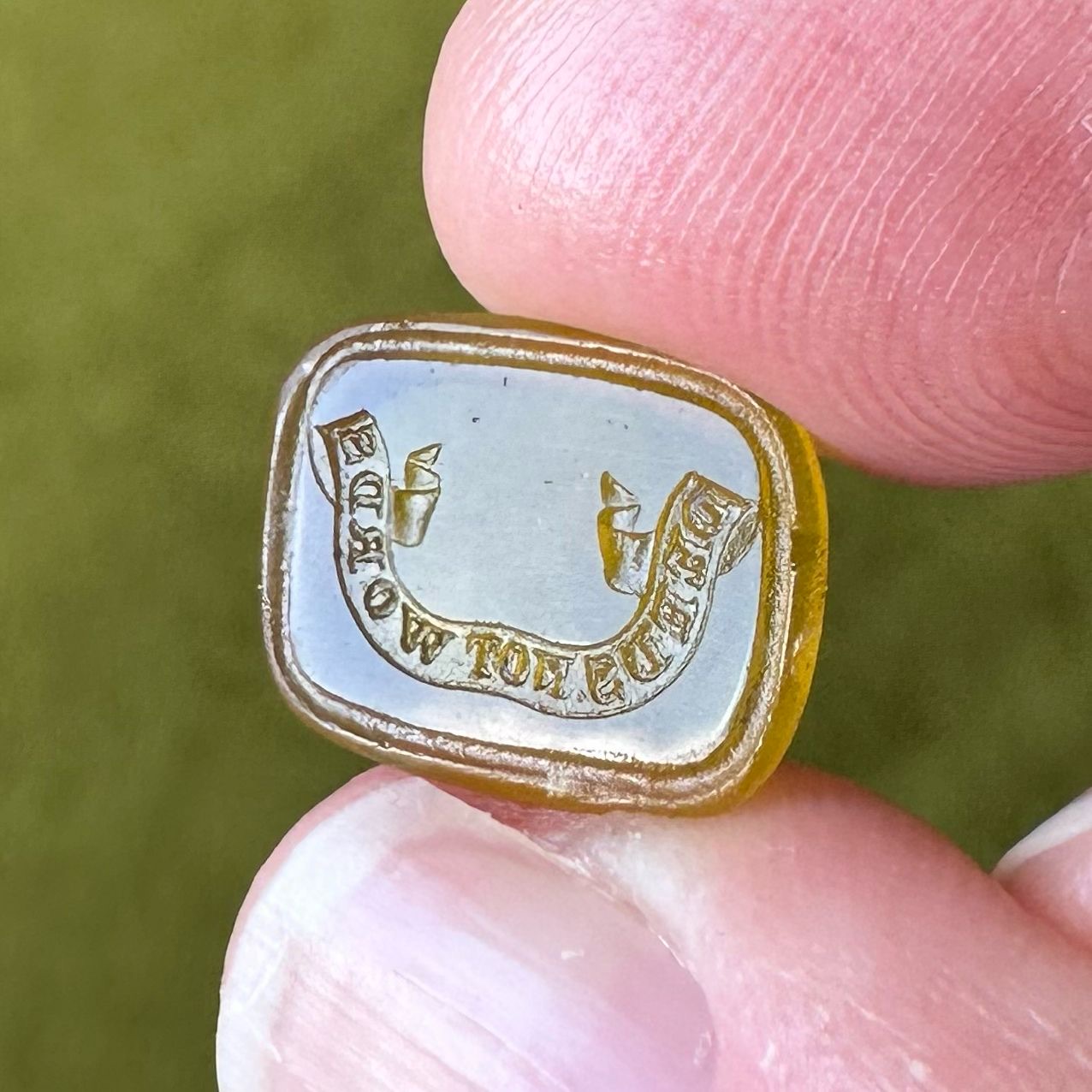 Golden yellow paste intaglio seal by James Tassie with a banner reading Deeds not Words