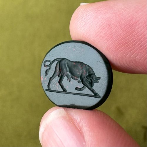 Oval bloodstone intaglio with detailed imagery of a charging bull