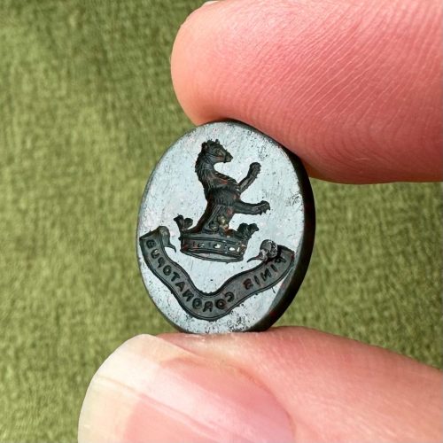 Oval bloodstone intaglio with heraldic imagery of a demi rampant muzzled bear emerging from a crown - Latin motto reads finis coronatopus (the end crowns the work)
