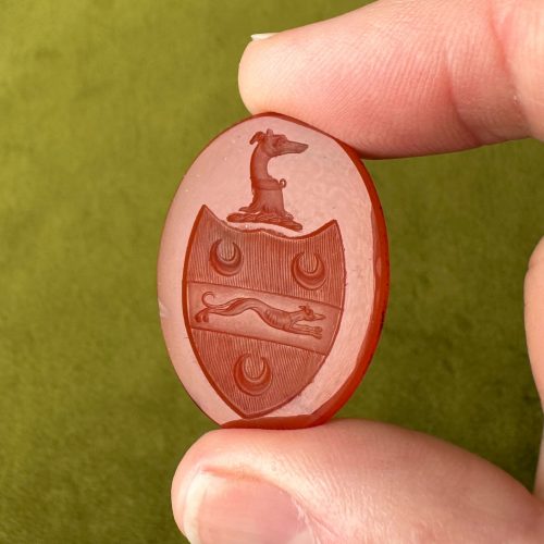 Large Georgian oval carnelian intaglio seal featuring imagery of a shield containing a running greyhound and three crescent moons, topped with a collared greyhound in profile