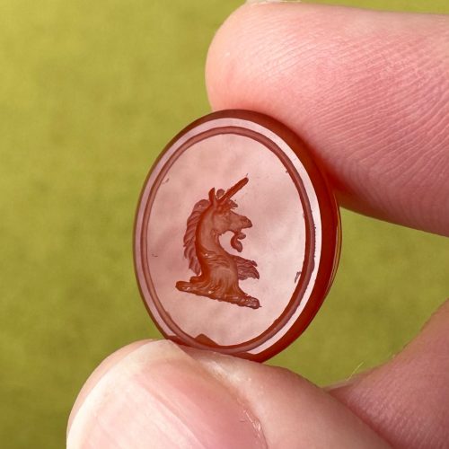 Paired down oval carnelian heraldic intaglio seal with engraving of a unicorn head in profile