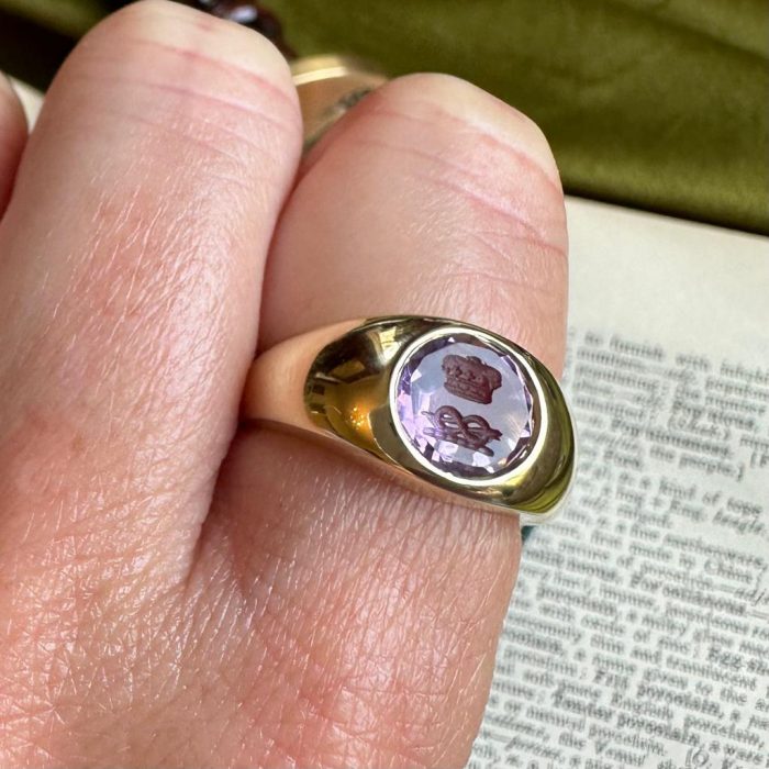 Close up of rubover intaglio seal ring on finger
