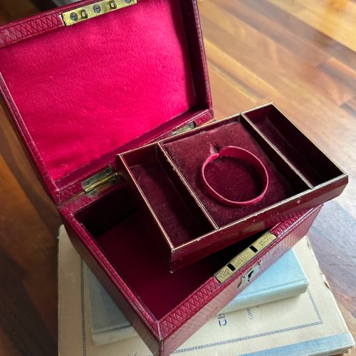 Inside of red leather jewellery box showing red velvet lining and tray